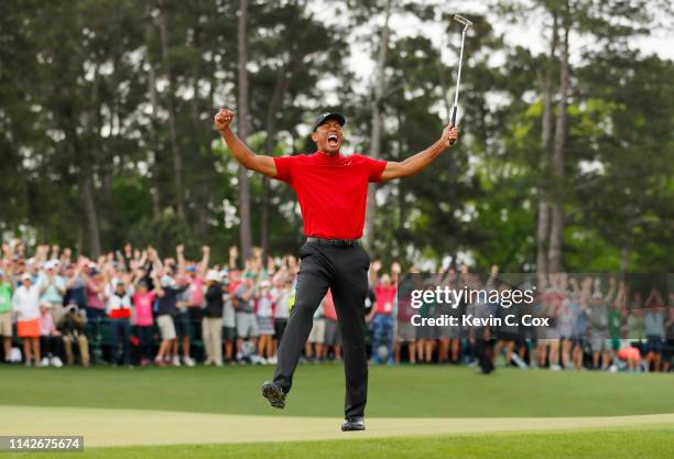 Tiger Woods of the United States celebrates after sinking his putt on the 18th green to win during the final round of the Masters at Augusta National...