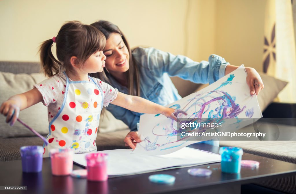 Niedliche kleine Mädchenmalerei mit Mama zusammen, Porträt von Mutter und Tochter Malerei zu Hause