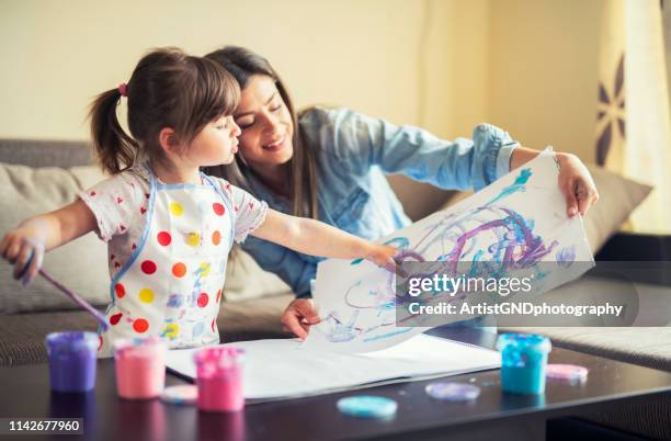 schattige kleine meisje schilderen met mama samen thuis, portret van moeder en dochter schilderij thuis - adult baby women stockfoto's en -beelden