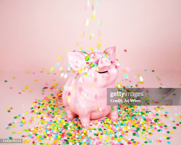 piggy coin bank with falling confetti - pink confetti stock pictures, royalty-free photos & images