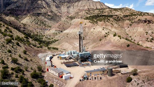 luchtfoto drone clip van een fracking boorinstallatie in de heuvels van colorado in de lente - fraccen stockfoto's en -beelden