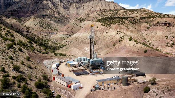 aerial drone clip of a fracking drill rig in the hills of colorado in the springtime - fracking stock pictures, royalty-free photos & images