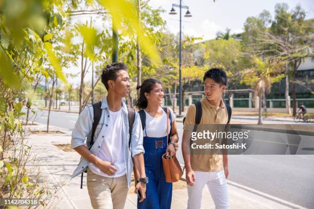 multi-ethnic asian friends walking in bonifacio global city in the morning - philippines friends stock pictures, royalty-free photos & images