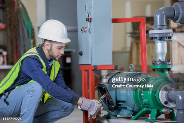 young engineer working on electrical equipment at oil and gas industry job site - pump jack stock pictures, royalty-free photos & images