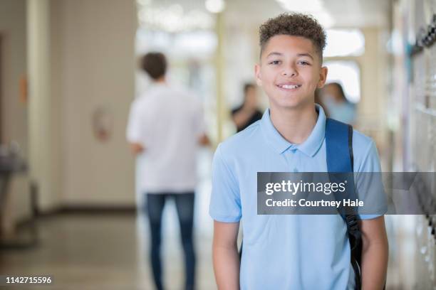 teen male standing in hallway at school - private school uniform stock pictures, royalty-free photos & images