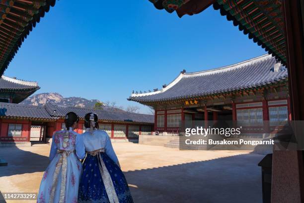 asian korean woman dressed hanbok in traditional dress walking in gyeongbokgung palace in seoul, south korea. - myeong dong fotografías e imágenes de stock