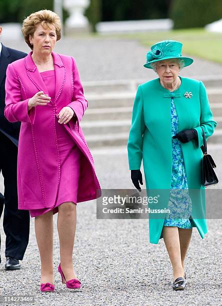 Queen Elizabeth II and Irish President Mary McAleese walk through the gardens of Aras an Uachtarain after a tree planting ceremony on May 17, 2011 in...