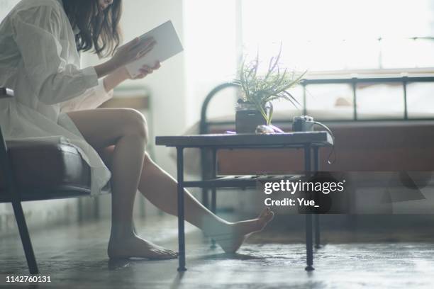 mujer joven leyendo en casa - paz interior fotografías e imágenes de stock