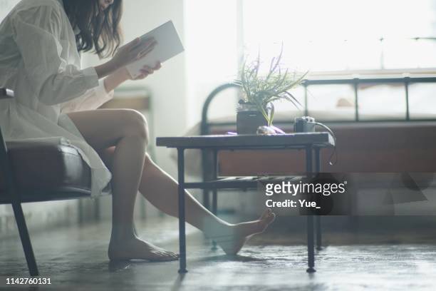 家で読書若い女性 - 心地よい ストックフォトと画像