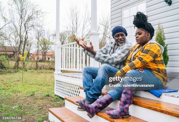 father and daughter hanging out on the porch. - stoop stock pictures, royalty-free photos & images