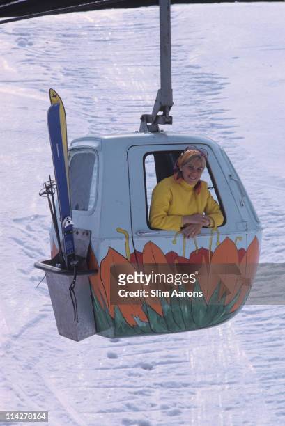 Woman leaning from the window of a cable car as it passes over the snow of the Sugarbush Mountain ski resort, one of the largest ski resorts in New...