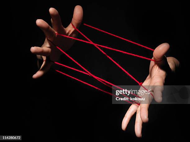playing cats cradle game. - rode draad stockfoto's en -beelden