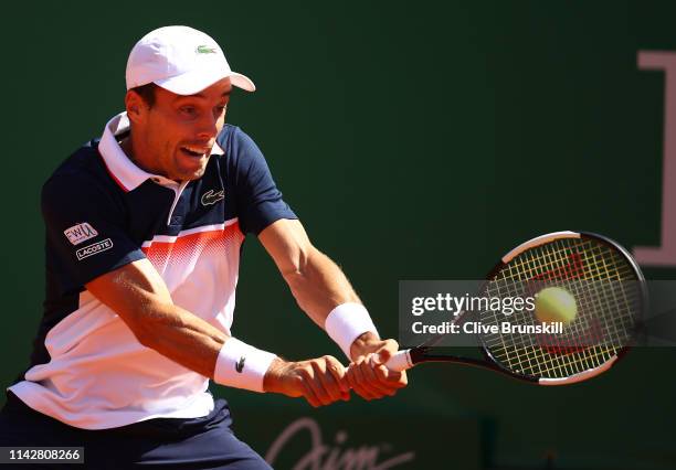 Roberto Bautista Agut of Spain plays a backhand against John Millman of Australia in their first round match during day two of the Rolex Monte-Carlo...