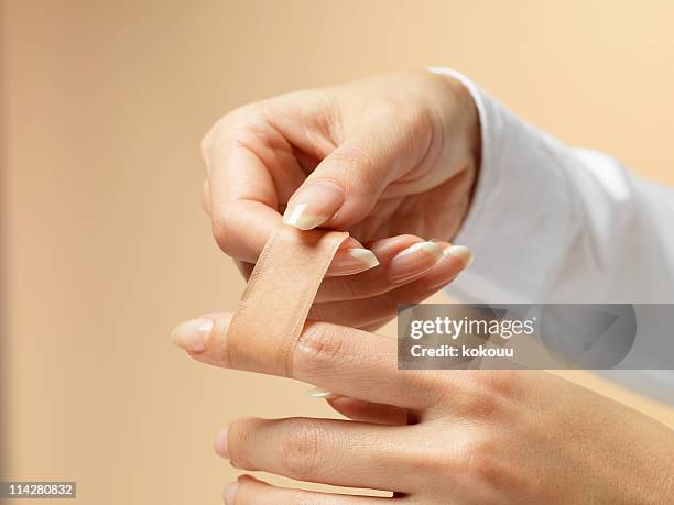 applying a band-aid - hand laceration stock pictures, royalty-free photos & images