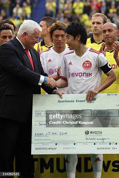 Chairman of the board of Evonik, Klaus Engel hands put a cheque of one Million Euro to support the foundation "Danilo Avelar of Schalke the children...