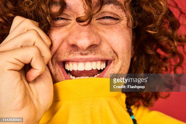colourful studio portrait of a young man - lachen stock-fotos und bilder