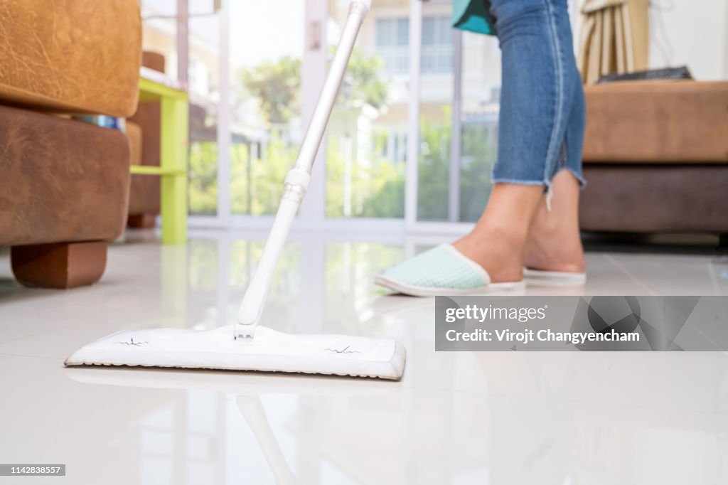 Woman cleaning floor house with mop