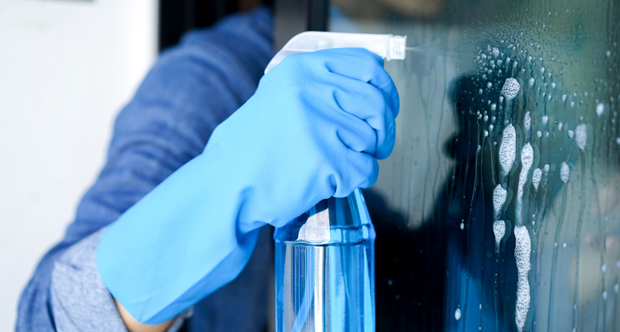 close up male housekeeper hand using spray bottle for cleaning dust on mirror door concept close up male housekeeper hand using spray bottle for cleaning dust on mirror door concept