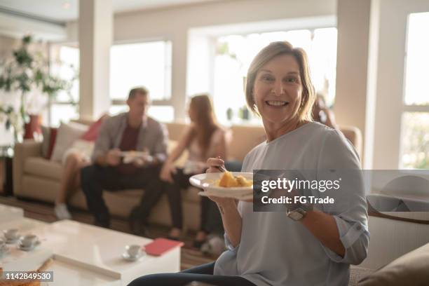 portret van rijpe vrouw eten taart op koffie familie tijd - coffee cake stockfoto's en -beelden