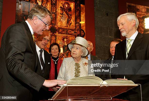 Queen Elizabeth II and Prince Philip, Duke of Edinburgh are shown the Book of Kells during a visit to Trinity College Dublin on May 17, 2011 in...