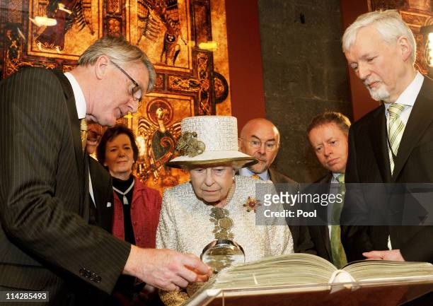 Queen Elizabeth II and Prince Philip, Duke of Edinburgh are shown the Book of Kells during a visit to Trinity College Dublin on May 17, 2011 in...