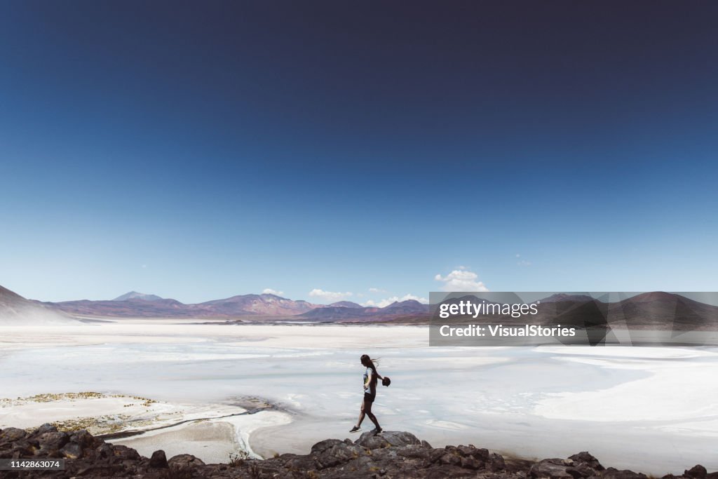 Woman exploring salt flat and volcanic landscape in Atacama desert