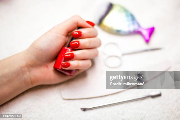 close-up of woman fingers with nail art manicure with bright red color - red nail polish stock pictures, royalty-free photos & images