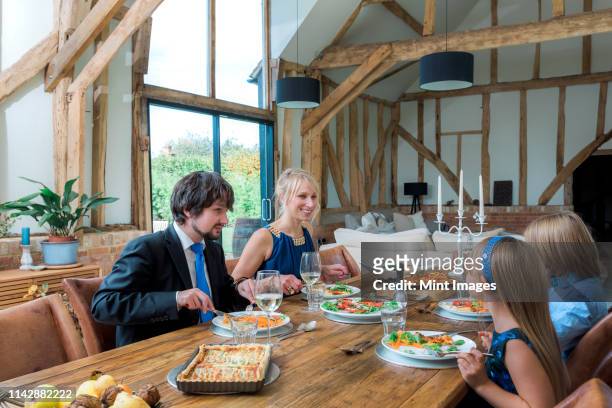 caucasian family eating dinner in dining room - wealthy family inside home stock pictures, royalty-free photos & images