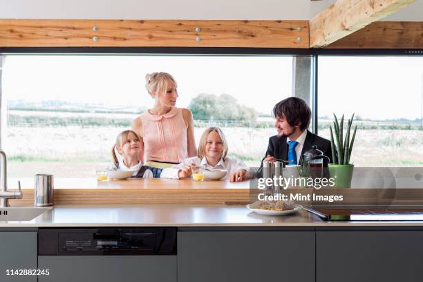 caucasian family eating breakfast in kitchen - dadaism stock pictures, royalty-free photos & images