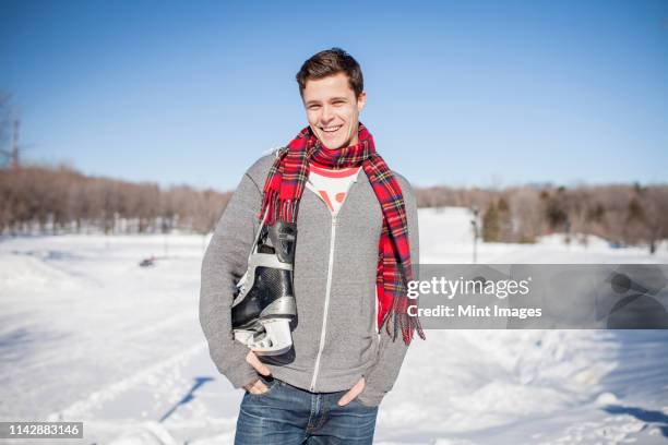 caucasian man carrying ice skates in snow - hockey skate stock pictures, royalty-free photos & images