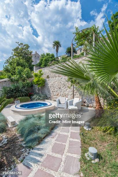 soaking pool and armchairs on hillside patio - símbolo de status imagens e fotografias de stock