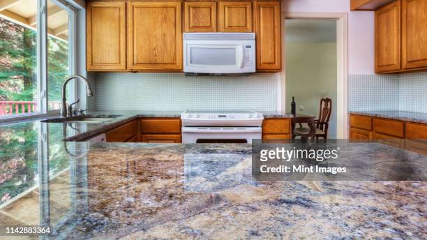 granite counter reflecting kitchen cabinets - kitchen worktop stock-fotos und bilder
