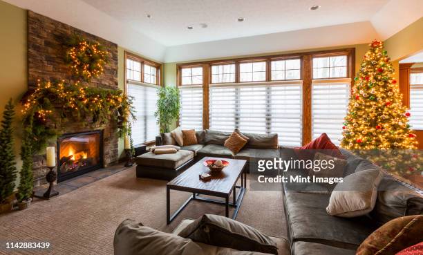christmas tree and mantle with sofas and fireplace in living room - ornate house furniture stock pictures, royalty-free photos & images