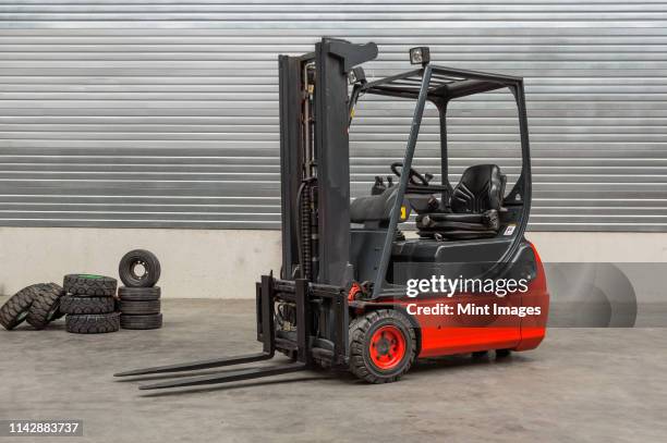 forklift machinery parked in warehouse - gabelstapler stock-fotos und bilder
