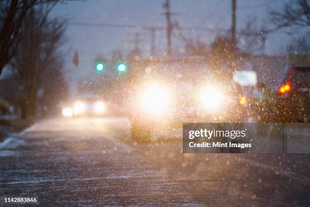 car driving on snowy urban street at night - sleet bildbanksfoton och bilder