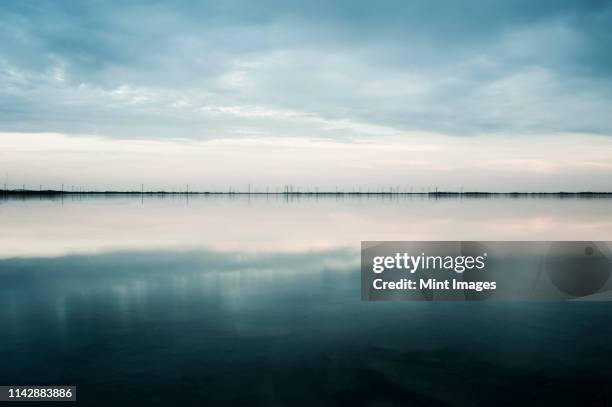 clouds reflected in still rural lake - remote guarding stock pictures, royalty-free photos & images