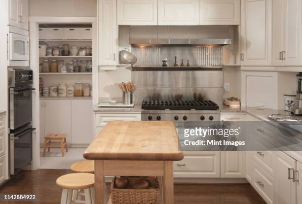 wooden counter and stove in modern kitchen - isla de cocina fotografías e imágenes de stock