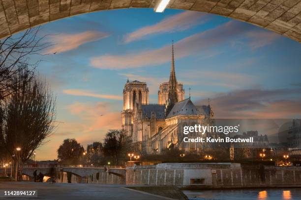 the iconic notre dame cathedral rises above the seine - kathedrale-von-notre-dame stock-fotos und bilder