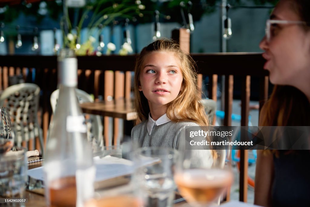 Family enjoying leisure time at restaurant terrace.