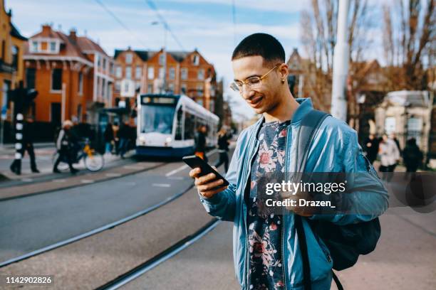 jahrtausende latino-student, der in europa lebt und öffentliche verkehrsmittel nutzt. - holländische kultur stock-fotos und bilder