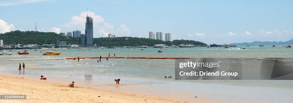 Tourists on Pattaya Beach with skyline.