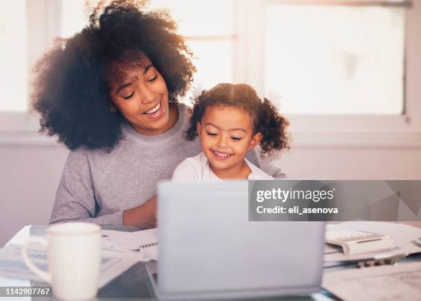 joven madre trabajando y pasando tiempo con su hija - working mother fotografías e imágenes de stock