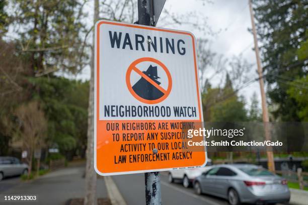 Sign warning of a neighborhood watch on a suburban street in Lafayette, California, April 4, 2019.