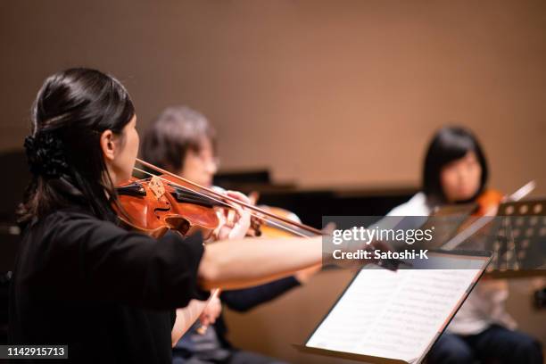 musiker spielen violine beim klassischen konzert - konzertsaal stock-fotos und bilder