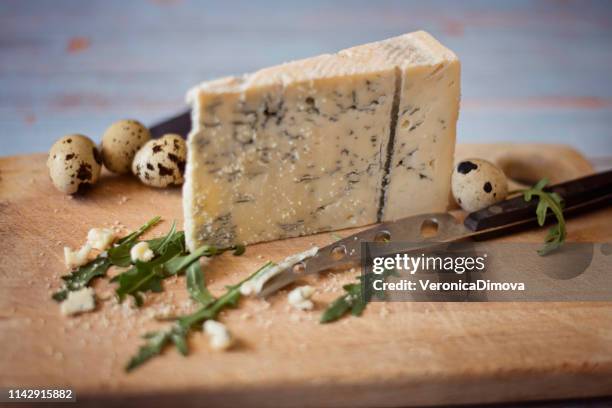 gorgonzola cheese on a chopping board with quail eggs - gorgonzola stock pictures, royalty-free photos & images