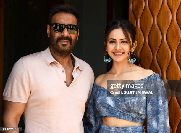 Indian Bollywood actor Ajay Devgn and actress Rakul Preet Singh pose for photographs during the promotion of their upcoming romantic comedy Hindi...