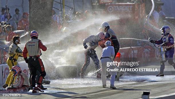 Mechanics of Brazilian driver Tony Kanaan, of the MoNunn Racing team are aided by team members after suffering an accident at the pit stop during a...