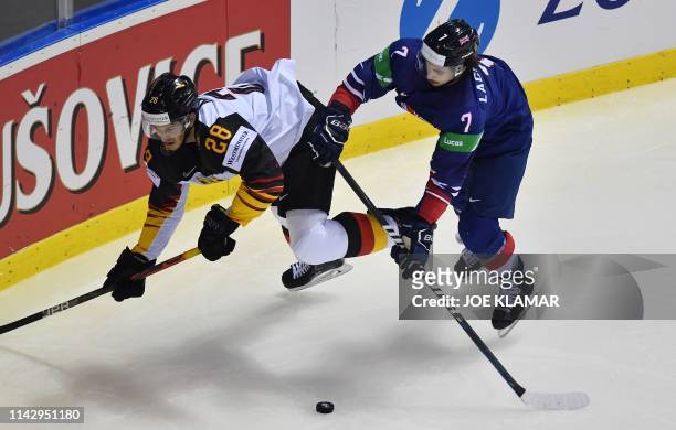 Frank Mauer of Germany and Robert Lachowicz of Great Britain vie for the puck during the group A stage match Germany vs Great Britain of the 2019...