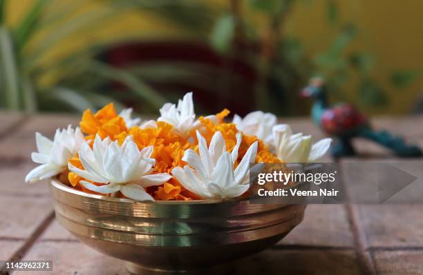 jasmine and marigold flowers in a brass utensil/urli - onam foto e immagini stock