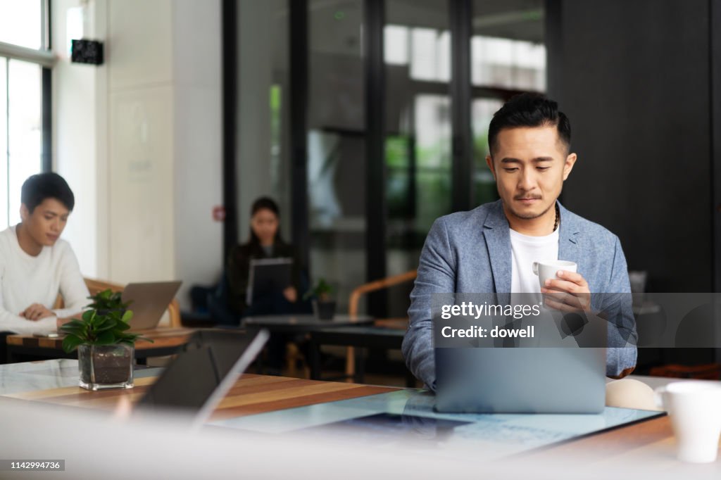 Young chinese business people working with laptop